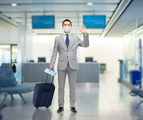 Image showing businessman in mask with travel bag at airport