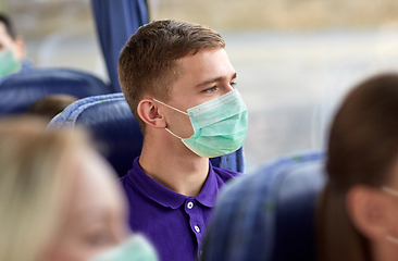 Image showing young man in medical mask sitting in travel bus