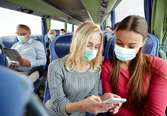 Image showing happy young women in travel bus with smartphone