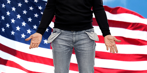 Image showing close up of man showing empty pockets over grey