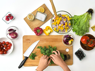 Image showing hands preparing parsley for salad on kitchen table