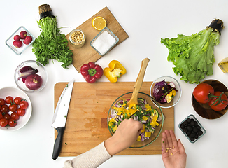 Image showing hands cooking vegetable salad on kitchen table