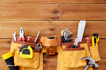 Image showing different work tools in belt on wooden boards