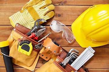 Image showing different work tools in belt on wooden boards