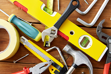 Image showing different work tools on wooden boards background