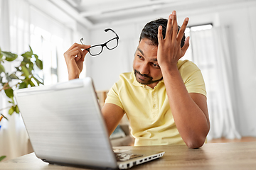 Image showing stressed man with laptop working at home office