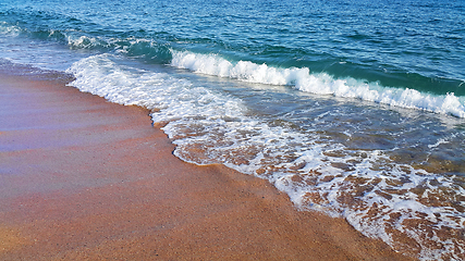 Image showing Sea wave with white foam on the coastal sand