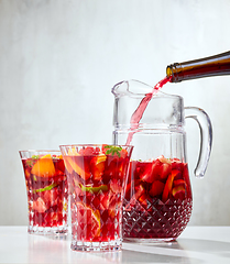 Image showing red wine pouring into jug