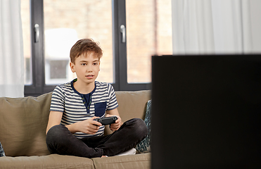 Image showing boy with gamepad playing video game at home