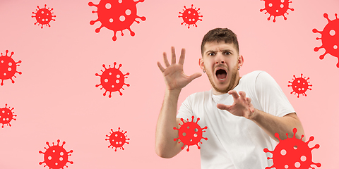 Image showing Young man scared of coronavirus spreading and worldwide cases, shocked, keeping quarantine