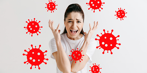 Image showing Young woman scared of coronavirus spreading and worldwide cases, shocked, keeping quarantine