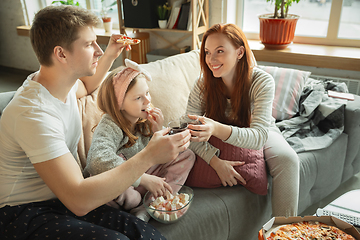 Image showing Family spending nice time together at home, looks happy and cheerful, eating pizza