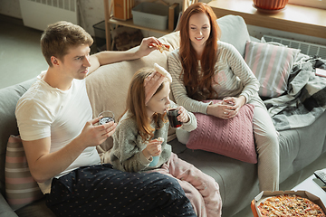 Image showing Family spending nice time together at home, looks happy and cheerful, eating pizza