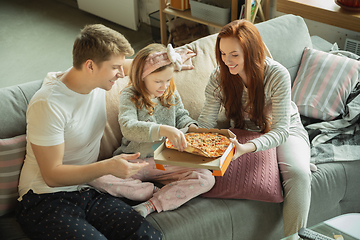 Image showing Family spending nice time together at home, looks happy and cheerful, eating pizza