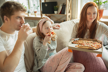 Image showing Family spending nice time together at home, looks happy and cheerful, eating pizza