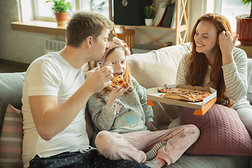 Image showing Family spending nice time together at home, looks happy and cheerful, eating pizza