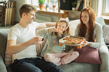 Image showing Family spending nice time together at home, looks happy and cheerful, eating pizza