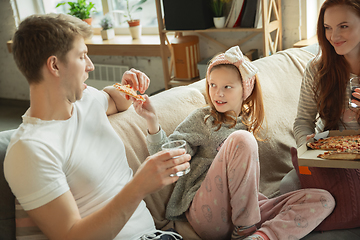 Image showing Family spending nice time together at home, looks happy and cheerful, eating pizza