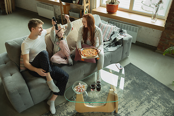 Image showing Family spending nice time together at home, looks happy and cheerful, eating pizza