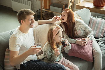 Image showing Family spending nice time together at home, looks happy and cheerful, eating pizza