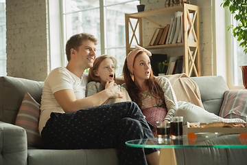 Image showing Family spending nice time together at home, looks happy and cheerful, eating pizza