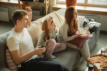 Image showing Family spending nice time together at home, looks happy and cheerful, eating pizza