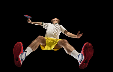 Image showing Young caucasian tennis player in action, motion isolated on black background, look from the bottom. Concept of sport, movement, energy and dynamic.