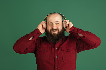 Image showing Handsome caucasian man portrait isolated on green studio background with copyspace