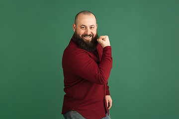 Image showing Handsome caucasian man portrait isolated on green studio background with copyspace