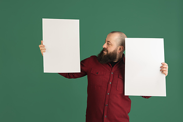 Image showing Handsome caucasian man portrait isolated on green studio background with copyspace