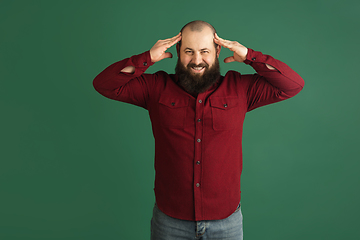 Image showing Handsome caucasian man portrait isolated on green studio background with copyspace