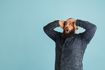 Image showing Handsome caucasian man portrait isolated on blue studio background with copyspace