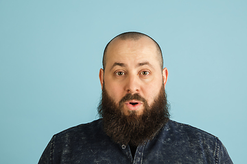 Image showing Handsome caucasian man portrait isolated on blue studio background with copyspace