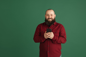 Image showing Handsome caucasian man portrait isolated on green studio background with copyspace