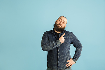 Image showing Handsome caucasian man portrait isolated on blue studio background with copyspace