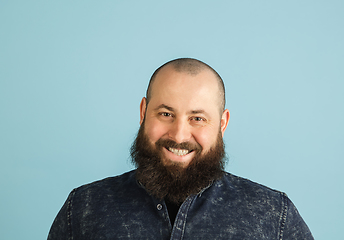 Image showing Handsome caucasian man portrait isolated on blue studio background with copyspace