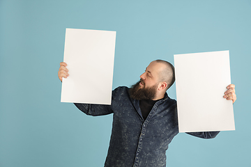 Image showing Handsome caucasian man portrait isolated on blue studio background with copyspace