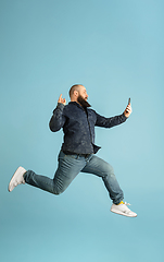 Image showing Handsome caucasian man portrait isolated on blue studio background with copyspace