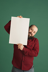 Image showing Handsome caucasian man portrait isolated on green studio background with copyspace