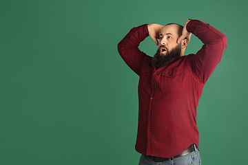 Image showing Handsome caucasian man portrait isolated on green studio background with copyspace