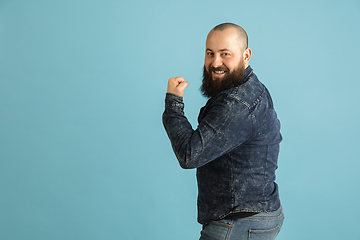 Image showing Handsome caucasian man portrait isolated on blue studio background with copyspace