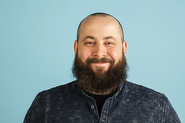 Image showing Handsome caucasian man portrait isolated on blue studio background with copyspace