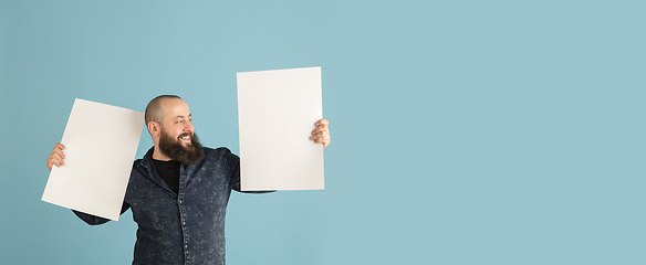 Image showing Handsome caucasian man portrait isolated on blue studio background with copyspace