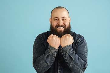 Image showing Handsome caucasian man portrait isolated on blue studio background with copyspace