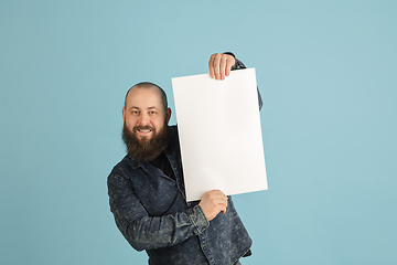 Image showing Handsome caucasian man portrait isolated on blue studio background with copyspace