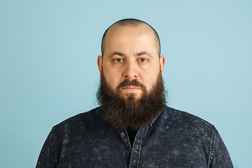 Image showing Handsome caucasian man portrait isolated on blue studio background with copyspace