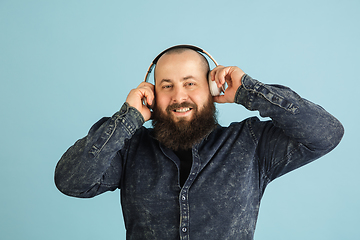 Image showing Handsome caucasian man portrait isolated on blue studio background with copyspace