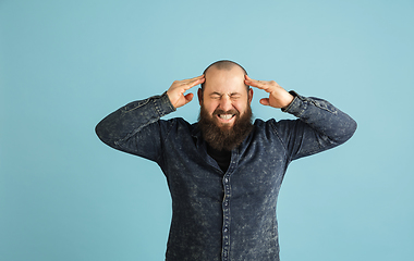 Image showing Handsome caucasian man portrait isolated on blue studio background with copyspace