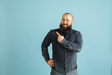 Image showing Handsome caucasian man portrait isolated on blue studio background with copyspace