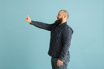 Image showing Handsome caucasian man portrait isolated on blue studio background with copyspace